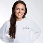 Person wearing a white sweatshirt with long dark hair, smiling against a plain background.