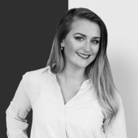 Black and white portrait of a smiling person in a white shirt.